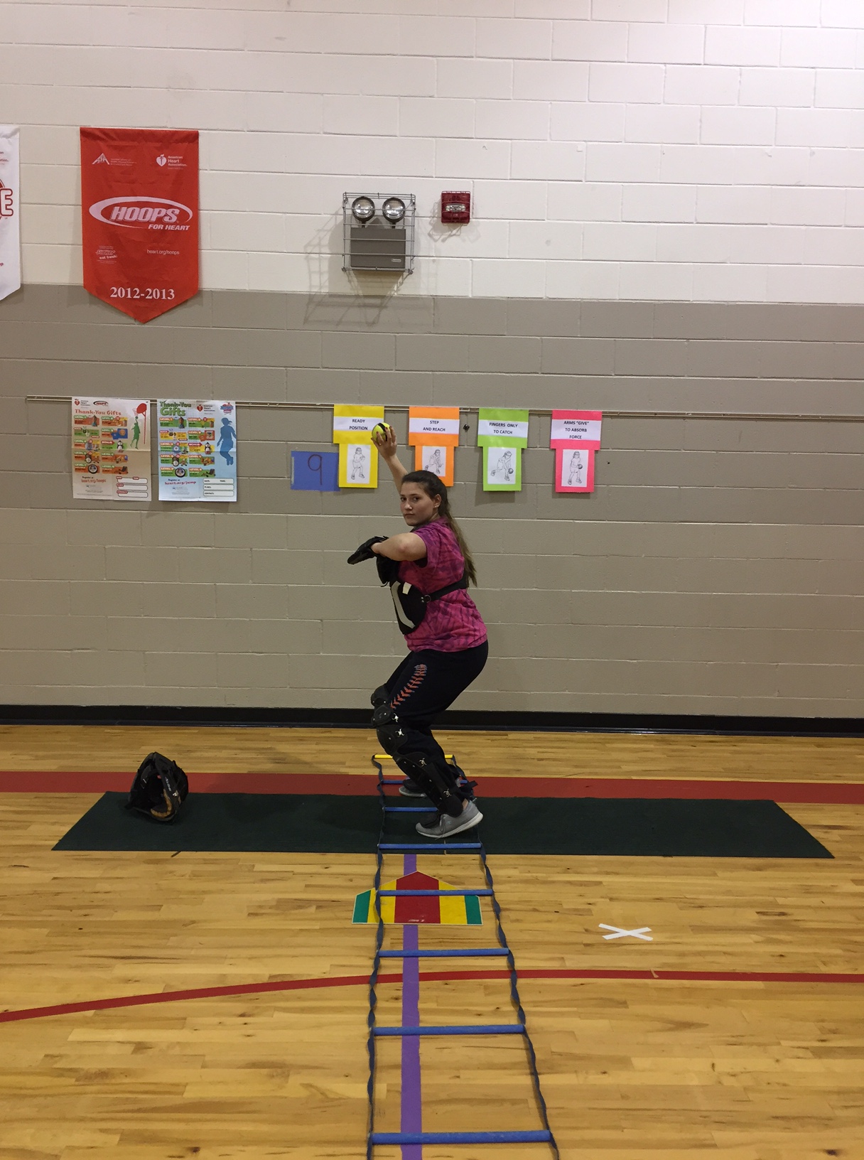 Fastpitch catcher jumping into the ladder to get aligned
