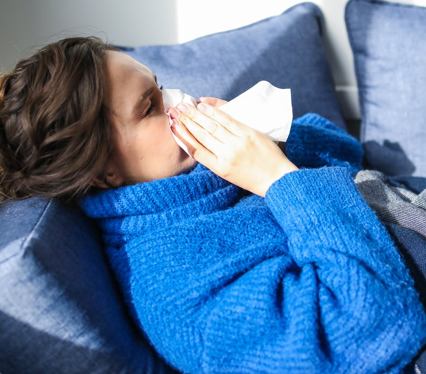 woman in blue sweater lying on bed
